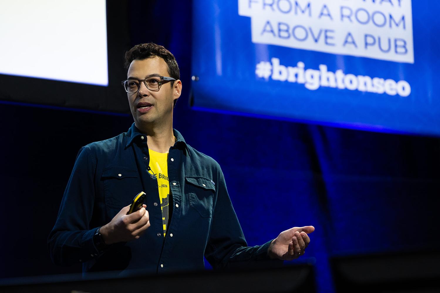 Gus Pelogia speaking on stage at brightonSEO